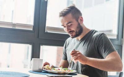Hombre comiendo un platillo saludable en casa, ejemplo de alimentación recomendada dentro de una dieta para apnea del sueño.