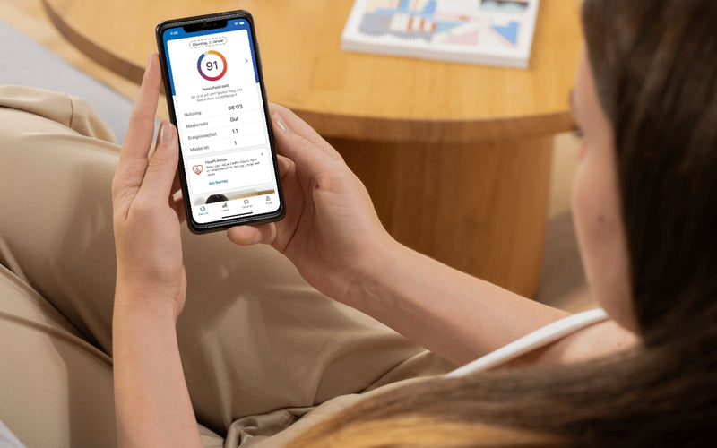 Mujer revisa en su celular la aplicación myAir de ResMed para dar seguimiento a su tratamiento con equipo CPAP.